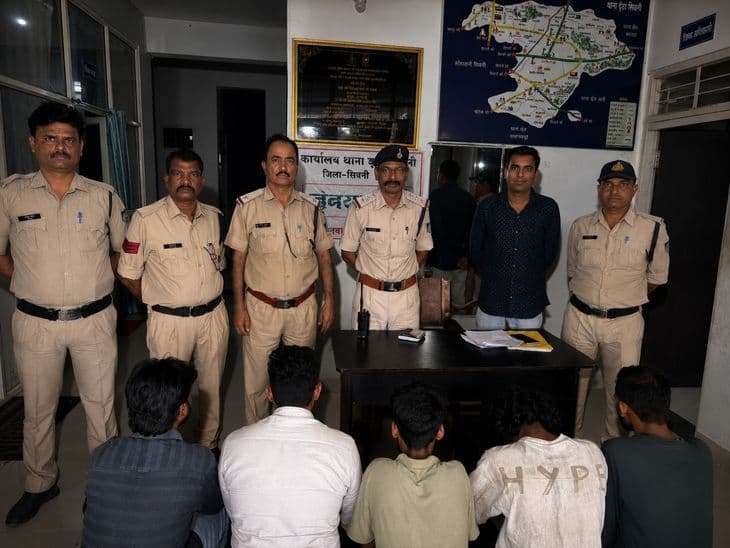 थाने में पुलिसकर्मी हिरासत में लिए गए संदिग्धों को प्रस्तुत करते हुए